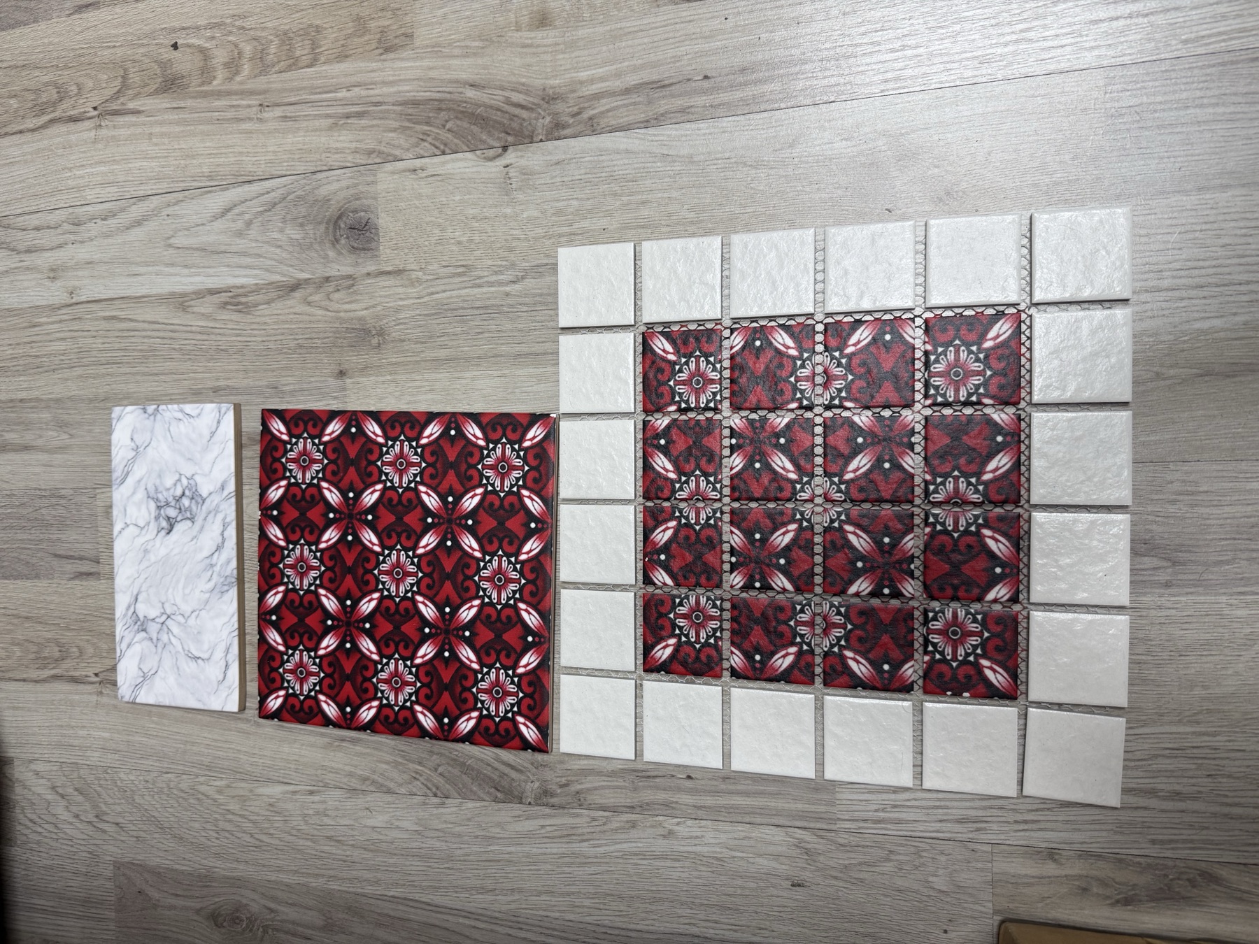 Printed red and black tile design displayed with matching tiles on a timber surface